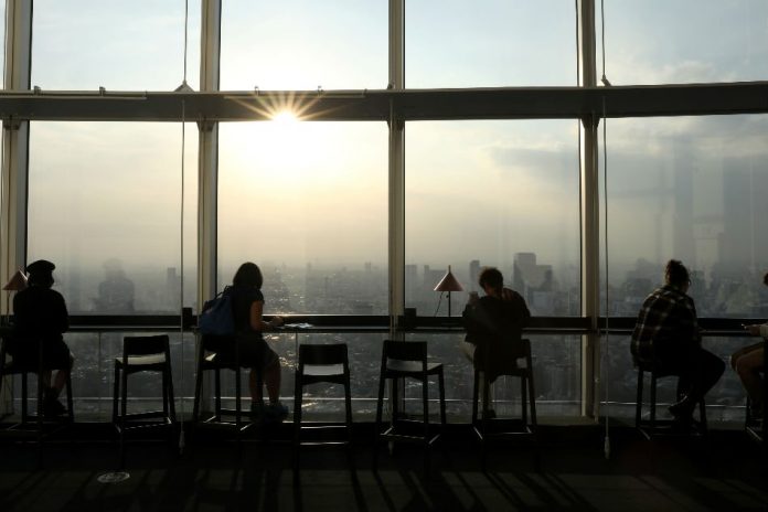 People are seen drinking coffee at the top of the Mori Tower in Roppongi, Tokyo, Japan. Despite a steady increase in coffee consumption around the world, trade prices have fallen dramatically in the past three years, hitting producers. MATTHEW CHILDS, REUTERS