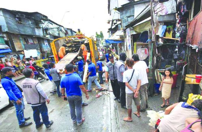 Demolition men help dismantle illegal structures that cause sidewalk obstruction along the road. The Department of the Interior and Local Government will implement a new 75-day road clearing operation to bolster government efforts to reclaim public roads. GMA NEWS