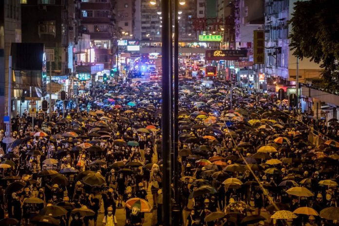 Demonstrators walk on the street during a protest in Hong Kong. PAUL YEUNG/BLOOMBERG