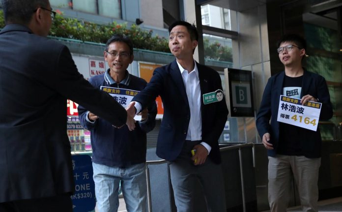 Winning candidate Kelvin Lam and activist Joshua Wong greet people and thank them for their support, outside of South Horizons Station, in Hong Kong, China on Nov. 25. REUTERS/LEAH MILLIS