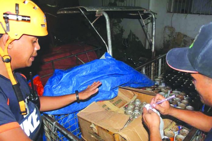 Authorities inspect these illegally refilled butane canisters seized from four persons at a checkpoint in Guimbal, Iloilo on Nov. 11. GUIMBAL FIRE STATION