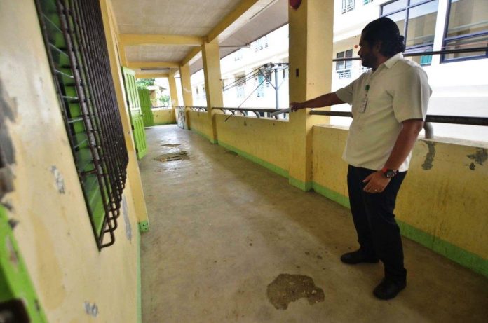 BUILDING IN DANGER. Iloilo City National High School administrative officer Khris Dane Dinopol points to huge indentations on the floor of this two-storey school building. The City Engineer’s Office has recommended that this building, built only in 2015 or four years ago, be vacated temporarily until the structural defect has been addressed. IAN PAUL CORDERO/PN