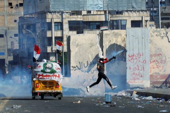 A demonstrator throws away a tear gas canister during an anti-government protest in Baghdad, Iraq on Nov. 1. REUTERS/KHALID AL-MOUSILY