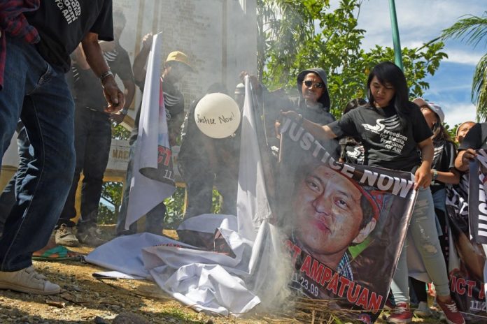 Children and relatives of the 32 journalists killed in the 2009 massacre burn giant tarps with photos of the Ampatuan clan, the political family tagged in the killings, during a visit at the massacre site in Masalay, Ampatuan town, Maguindanao last year. FROILAN GALLARDO/ABS-CBN NEWS