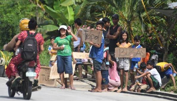 Quake-hit residents staying outside evacuation centers are seen begging for help along the main highway of Tulunan, Cotabato on Saturday, two days since a third major quake rattled Mindanao in 16 days. ABS-CBN NEWS