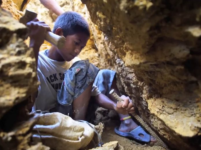 A young boy is looking for gold in a mining pit. LARRY PRICE/PULITZER CENTER