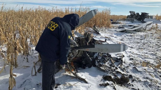 An investigator checks the wreckage of a plane on Monday. The South Dakota plane crash on Saturday has killed nine members of a prominent United States business family. NATIONAL TRANSPORTATION SAFETY BOARD