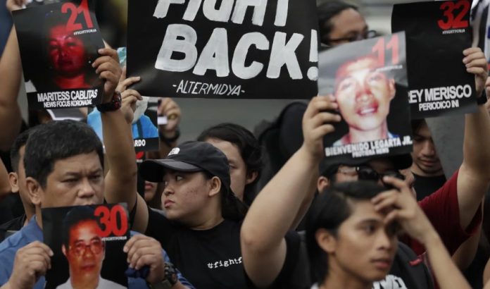 Campaigners in Manila hold pictures of victims as they mark the 10th anniversary of the massacre of 58 people, on November 23, 2019. AP