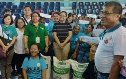 Bago City agriculturist Carlito Indencia (right) with farmers who received an initial 3,000 bags of certified rice seeds from the Department of Agriculture in Western Visayas during the turn-over rites at the Manuel Y. Torres Memorial Coliseum and Cultural Center on Dec. 12. PHOTO COURTESY OF BAGO CITY AGRICULTURE OFFICE