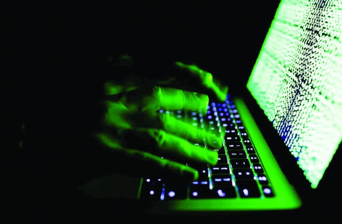 A man types on a computer keyboard in front of the displayed cyber code. Cyber criminals are expected to target the financial industry – particularly financial technology such as mobile investment applications – in 2020, Russian cybersecurity firm Kaspersky said. REUTERS