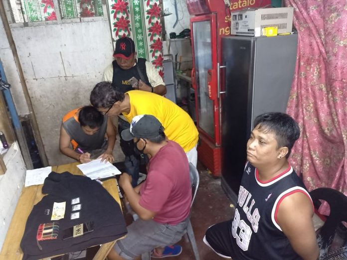 Antidrug operatives inspect items seized from “high-value” suspect Junel Salazar during an entrapment operation in Barangay 6, Bacolod City on Dec. 28. POLICE STATION 3/BCPO