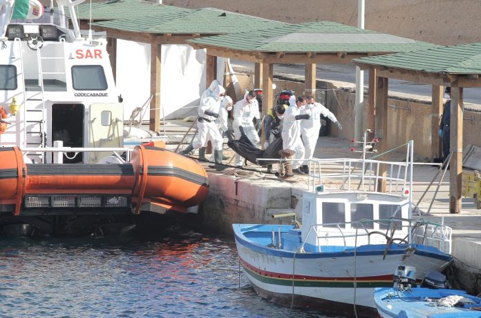 Italian coastguards carry the body of a migrant victim of a boat that capsized off the Italian coast, on the island of Lampedusa, Italy on Nov. 30. REUTERS/MAURO BUCCARELLO