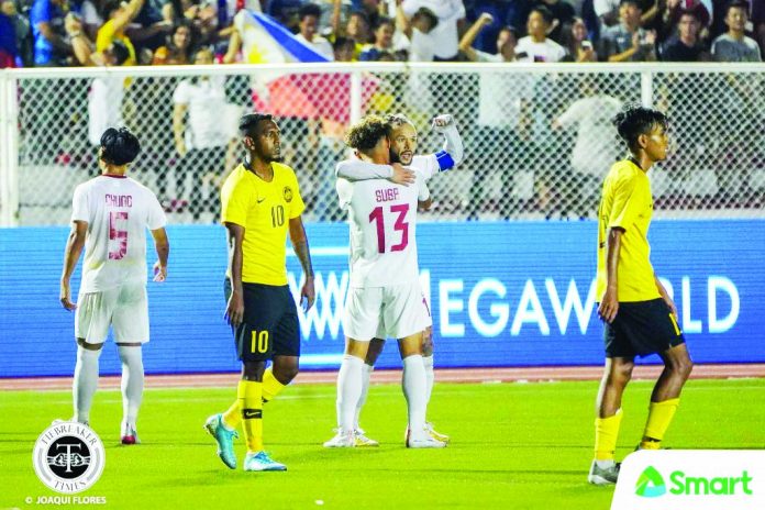 Stephan Schrock is hugged by a teammate after scoring a goal against Malaysia. TIEBREAKER TIMES PHOTO