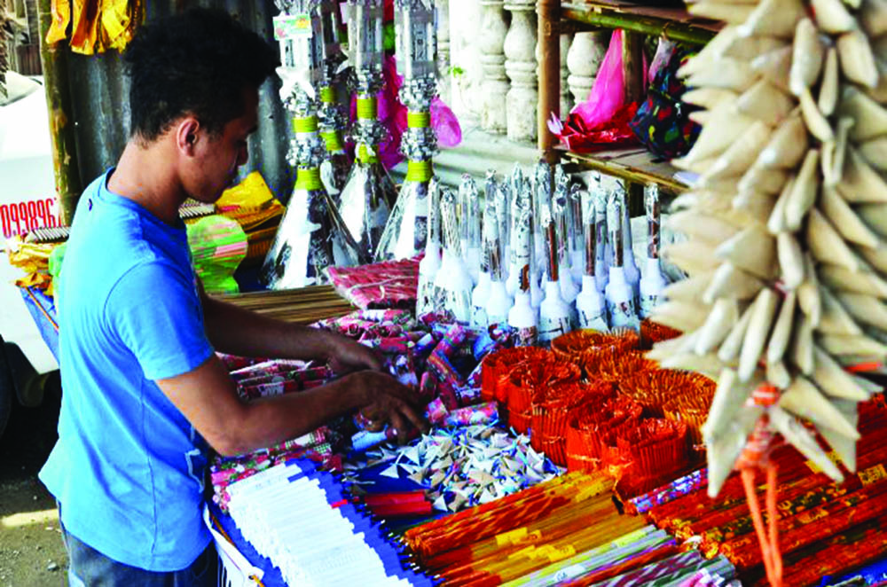 A firecracker vendor in Tigbauan, Iloilo attends to his goods. Firecrackers can only be sold in designated zones set by the local government unit in coordination with the Philippine National Police and the Bureau of Fire Protection. 