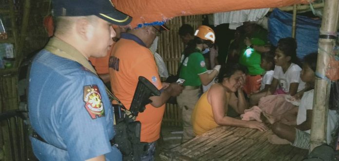 A police officer and rescue personnel assist the family of Jestoni Cabrillos who drowned in a river in Barangay Nanca, E.B. Magalona, Negros Occidental on Jan. 15. E.B. MAGALONA MUNICIPAL POLICE STATION