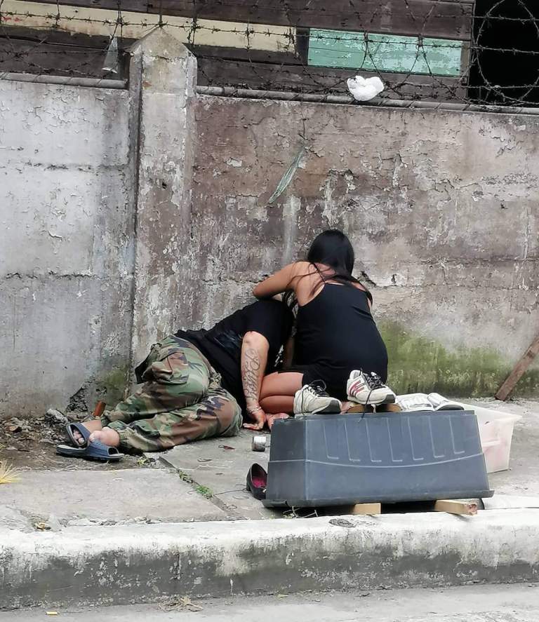 SHOT DEAD. A woman comes to the aid of call center agent Alain Muller who falls to the ground after being shot by masked men in Barangay Cuartero, Jaro, Iloilo City a little past noon on Jan. 19, 2020. Muller, a drug suspect, died. PHOTO BY JOMARIE HIMALAYA