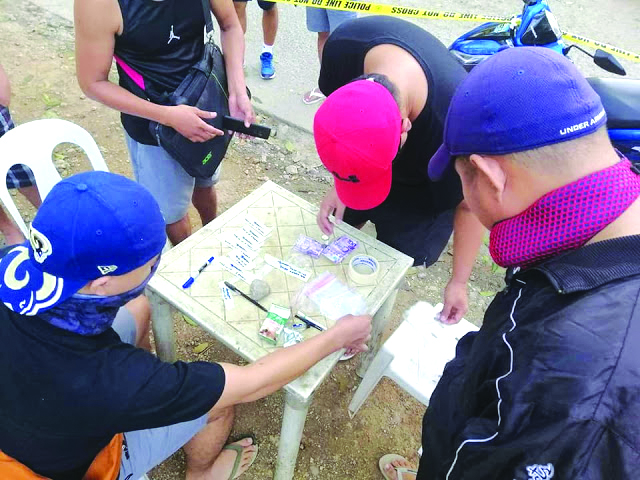 Antidrug operatives inspect these items seized from 44-year-old Mary Jane and 18-year old Shaila Morales of Panay, Capiz. They were both nabbed in a drug buy-bust operation in Boracay Island, Malay, Aklan. MALAY POLICE STATION