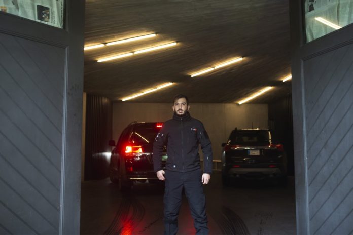 A private security guard watches journalists through a closing garage door after a vehicle arrived at the house of ex-Nissan chief Carlos Ghosn in Beirut, Lebanon, Saturday, Jan. 4, 2020. AP