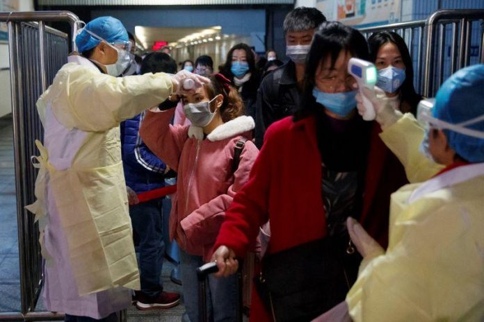 Medical workers take the temperature of passengers after they got off the train in Jiujiang, Jiangxi province, China on Jan. 29. REUTERS/THOMAS PETER