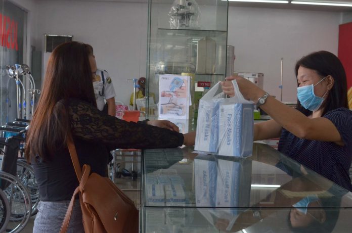 PANIC BUYING? A woman buys two boxes of facemasks from a pharmacy in Jaro, Iloilo City. The pharmacy attendant herself is wearing a facemask. Demand for facemask is expected to further rise with the Department of Health’s confirmation of the first case of infection from a novel coronavirus – a Chinese tourist currently confined in a hospital in Manila. IAN PAUL CORDERO/PN