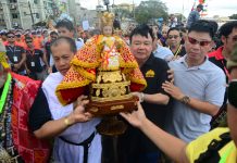 Reverend Father Edcel Alcayaga of the Parish of San Jose de Placer and Mayor Jerry Treñas of Iloilo City carry the Señor Santo Niño for a foot procession after the fluvial parade at the Iloilo River.