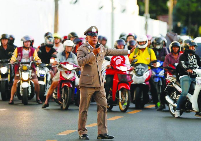 A Thai traffic police officer stops vehicles as King Maha Vajiralongkorn’s convoy passes near the Grand Palace, ahead of the King’s coronation, in Bangkok, Thailand on May 2, 2019. REUTERS/SOE ZEYA TUN/FILE PHOTO