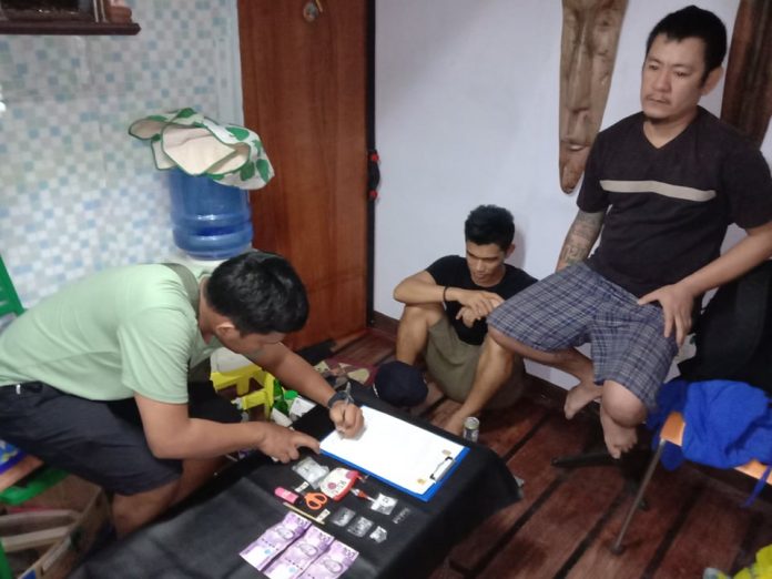 An antidrug officer inspects the items seized from drug suspects Rish Ivan Javier and Ryan Libre during an entrapment operation in Barangay 1, Bacolod City on Jan. 29. POLICE STATION 2/BCPO