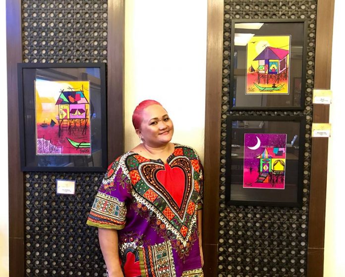 The artist at a previous exhibition with her watercolor paintings.