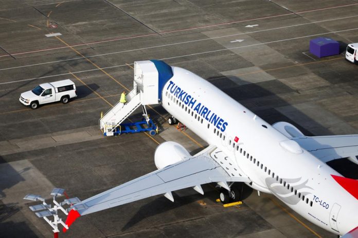 An aerial photo shows a worker climbing up to a Turkish Airlines Boeing 737 MAX airplane grounded at Boeing Field in Seattle, Washington, United States. REUTERS