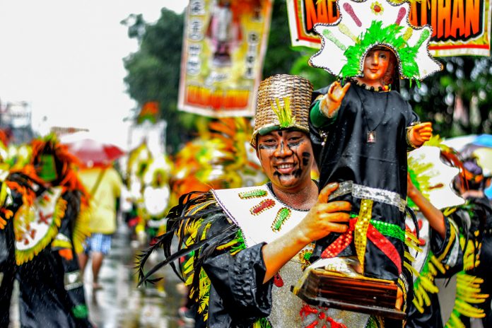 A performer holds an image of the Santo Niño. The Ati-Atihan Festival is among the religious celebrations in the Philippines which centers on the devotion to Child Jesus. IAN PAUL CORDERO/PN