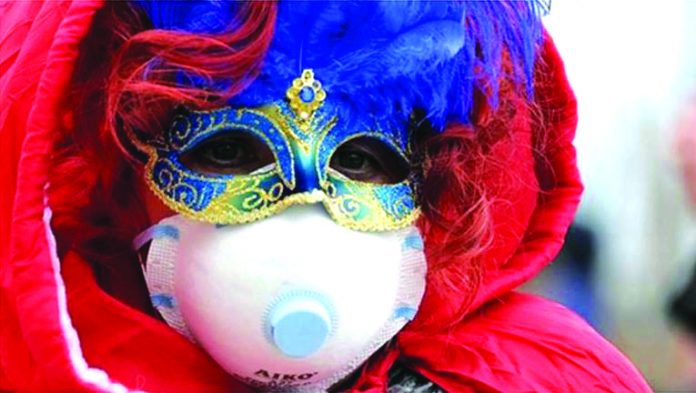 A Carnevale di Venezia participant in Italy wears two masks – a carnival mask for the festival and a facemask to avoid catching a new coronavirus. BBC