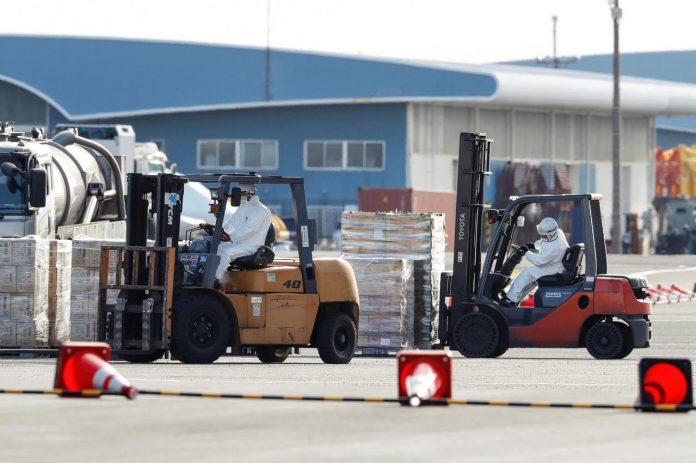 Workers wearing protective gear prepare to load supplies on to the cruise ship Diamond Princess, where 10 people on the ship had tested positive for coronavirus, after it arrived at Daikoku Pier Cruise Terminal in Yokohama, south of Tokyo, Japan on Feb. 6. REUTERS/KIM KYUNG-HOON