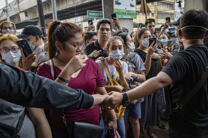 People wait outside a store to purchase protective masks in Manila on Jan. 31. Getty Images