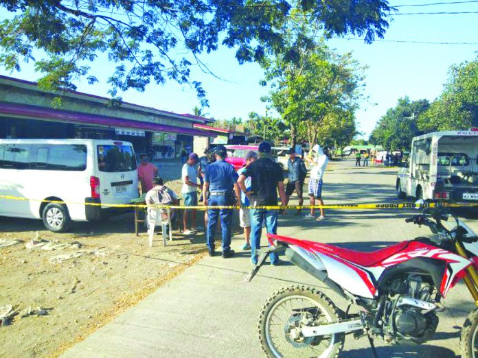 Drugs suspect Von Adrian Segura sits as antidrug officers inspect items seized from him during an entrapment operation in Barangay Funda-Dalipe, San Jose, Antique on Feb. 16. STEPHEN LOUIE CHECA/PN