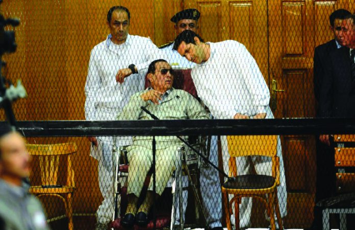 Former Egyptian president Hosni Mubarak, who faced multiple charges after his overthrow, including over the deaths of protesters in 2011 and for corruption, appeared with his two sons Alaa (R) and Gamal at their trial in Cairo in September 2013. AFP