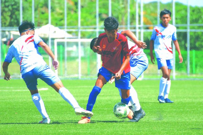 A Negros Occidental player carves for space against opposing defenders. PFF