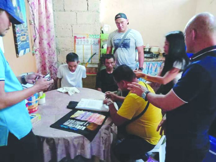 Antidrug officers inspect items seized from drug suspects Segundo Iglesia Jr., Jeronimo Demafelis and Rosalin Iglesia. They were nabbed in an entrapment operation in Barangay Villamonte, Bacolod City on Feb. 27. POLICE STATION 4/BCPO