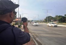 SPEED CHECK. A traffic enforcer checks the speed of these vehicles on Sen. Benigno Aquino Jr. Avenue, a traffic discipline zone in Mandurriao, Iloilo City. Drivers’ lack of discipline contributes to traffic congestion and causes vehicular accidents. PN PHOTO