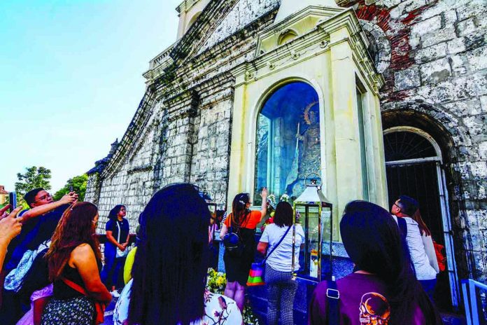 Devotees pray fervently in front of the baldachin where one can fully gaze the stone image of Nuesta Señora de la Candelaria (Our Lady of Candles) perched on the balcony of the Jaro Metropolitan Cathedral in Iloilo City’s Jaro district. Today, thousands of devotees are expected to come to the church and visit the image widely believed to be miraculous. IAN PAUL CORDERO/PN