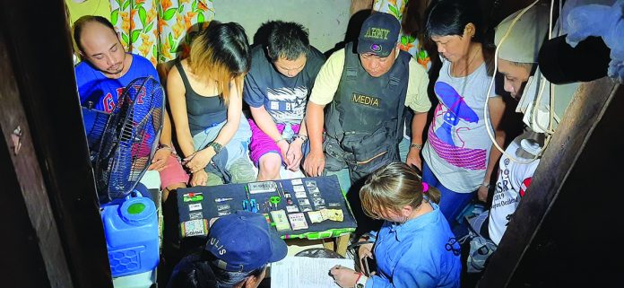 Antidrug officers inspect items seized from Samuel Sumagaysay, Melanie Del Valle and Sergion Rivera. The suspects were nabbed in an entrapment operation in Barangay 12, Bacolod City on Feb. 6. POLICE STATION 1/ BCPO