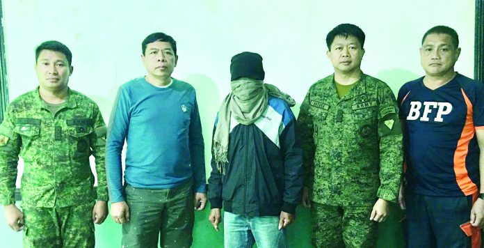 Authorities facilitate the surrender of New People's Army (NPA) member “Cardo” (3rd from left) at Camp Monteclaro, Barangay Igtuba, Miag-ao, Iloilo on Feb. 22. The surrenderee was under the NPA's Southern Front, Komiteng Rehiyon-Panay, which operates in Tubungan, Iloilo. CONTRIBUTED PHOTO