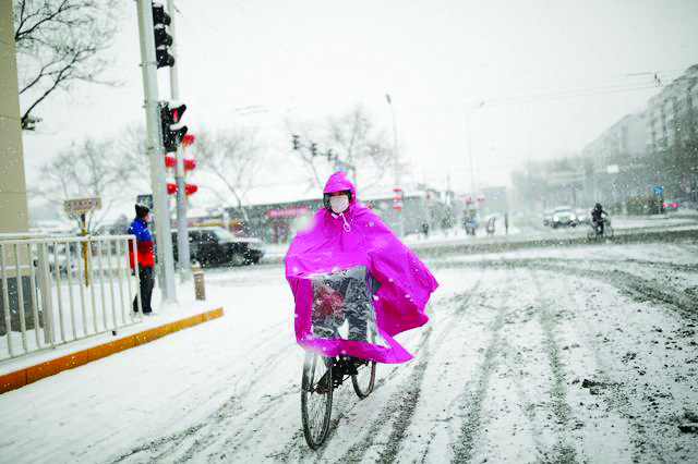 This woman wearing a facemask rides a bicycle amid snow, as China is threaten by an outbreak of the novel coronavirus. REUTERS