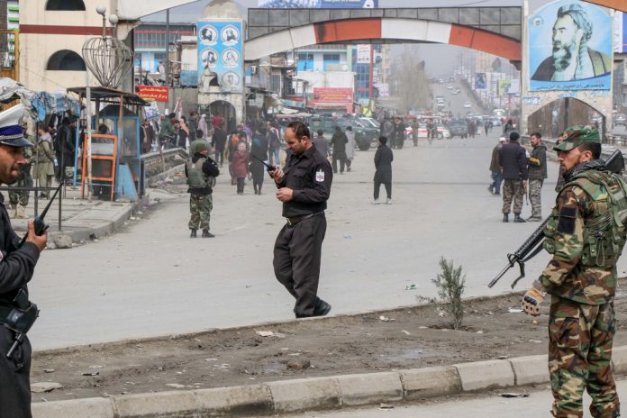 Afghan security forces personnel stand guard on a road near the site of a gun attack in Kabul March 6, 2020. AFP