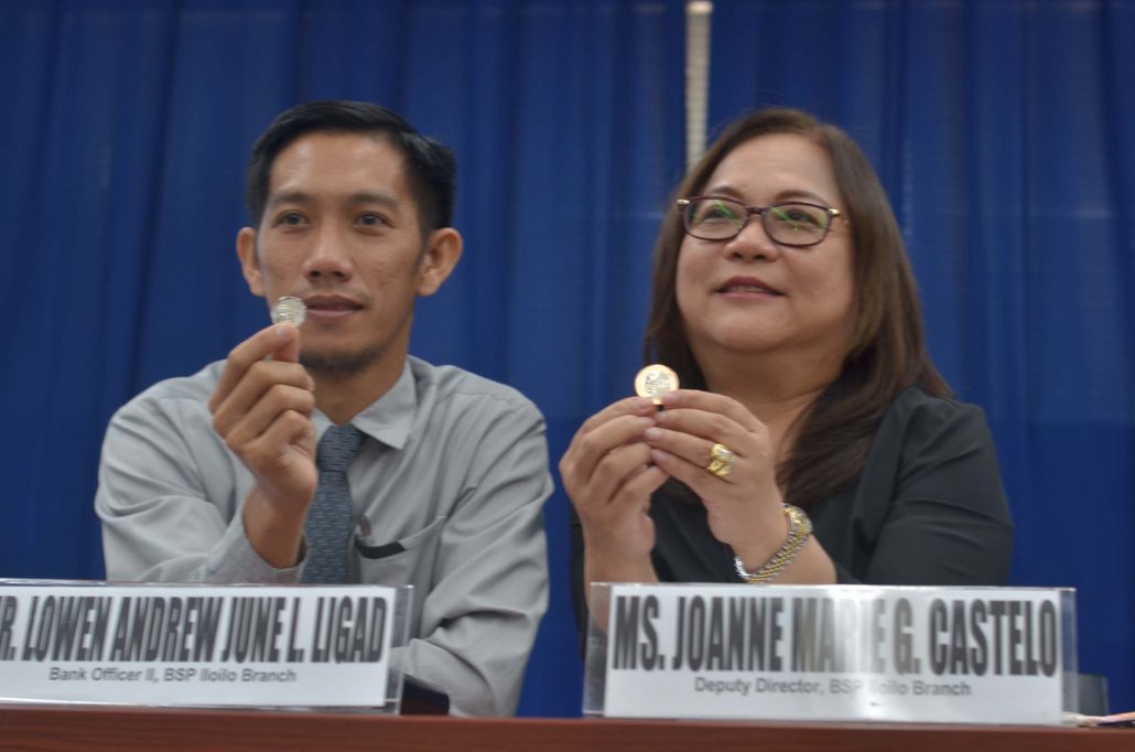 Bangko Sentral ng Pilipinas-Iloilo deputy director Joanne Marie Castelo (right) and Lowen Andrew June Ligad, bank officer, present the new P20 coin and the enhanced version of the P5 coin. IAN PAUL CORDERO/PN