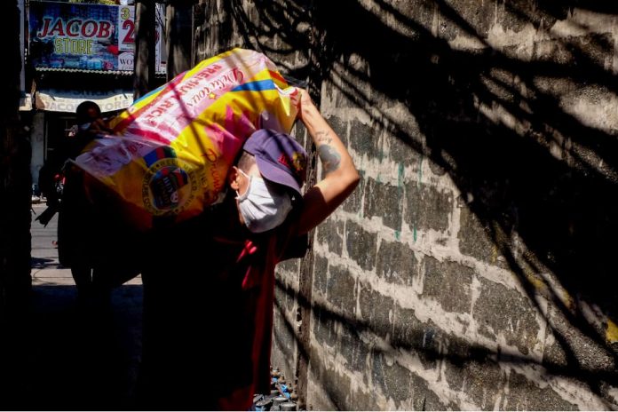 A volunteer transports food aid in Barangay Batis in San Juan City on Mar. 23, 2020. ABS-CBN