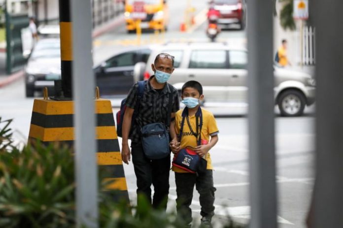 A man and a child wearing masks at Greenhills district in Manila, Philippines, on March 6, 2020. EPA-EFE