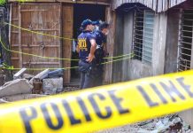 Policemen secure the house of a former barangay tanod in Barangay 9, Tigbauan, Iloilo.The ex-tanod was shot to death inside the house on Monday night, March 2, 2020. IAN PAUL CORDERO/PN