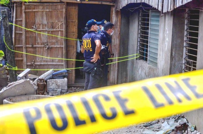 Policemen secure the house of a former barangay tanod in Barangay 9, Tigbauan, Iloilo.The ex-tanod was shot to death inside the house on Monday night, March 2, 2020. IAN PAUL CORDERO/PN