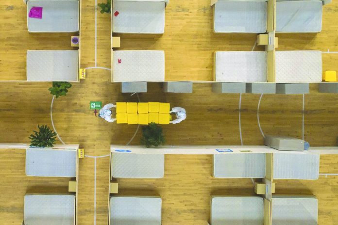 In this March 8, 2020, photo released by Xinhua News Agency, an aerial view shows staff members clean up an empty makeshift hospital in Wuhan, central China's Hubei Province. AP