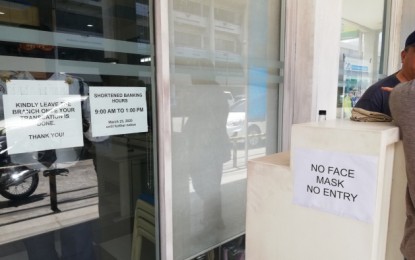 A bank branch in Bacolod City posts notices of its adjusted banking hours and “no mask, no entry” policy which took effect on Monday, Mar. 23. PNA